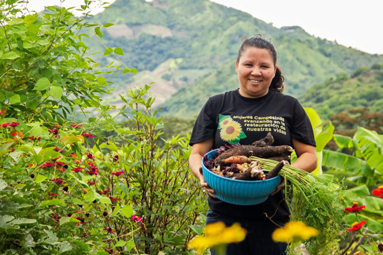 Luz Marina Valle shows off produce after working with the Fundación Entre Mujeres in Nicaragua.