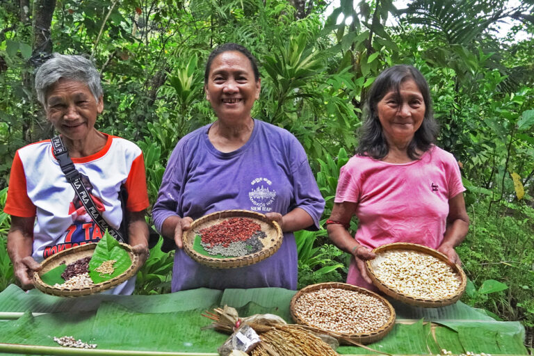 Elder women members of the Kiday Farmers Community Association' proudly show a variety of heirloom seeds they store to support organic farmers in their riverside hamlet in Quezon province.