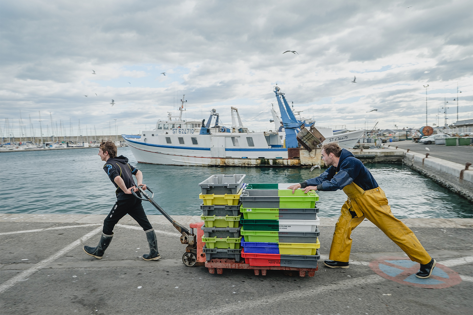 Fishermen transporting fish crates.