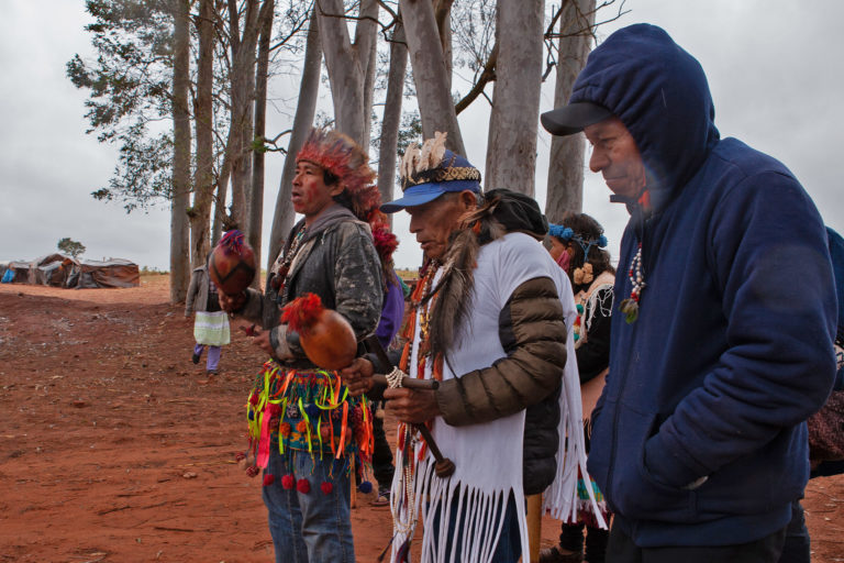 A group of Guarani-Kaiowá residents dance and chant.