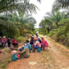 Oil palm plantation workers wait for the truck to take them to work.