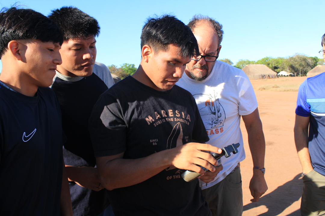 Kalutata Kuikuro, president of the Kuikuro do Alto Xingu Indigenous Association (AIKAX), views drone images along with researcher Wetherbee Dorshow. 